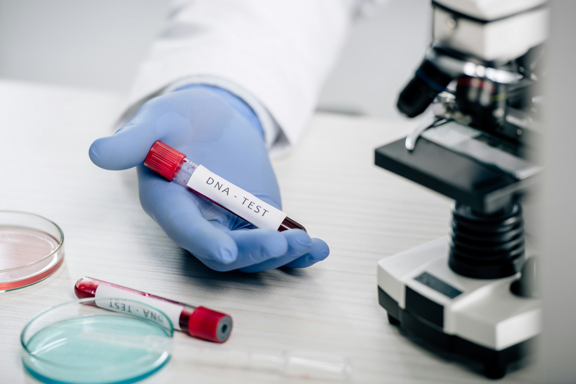 cropped view of genetic consultant holding test tube with dna test
