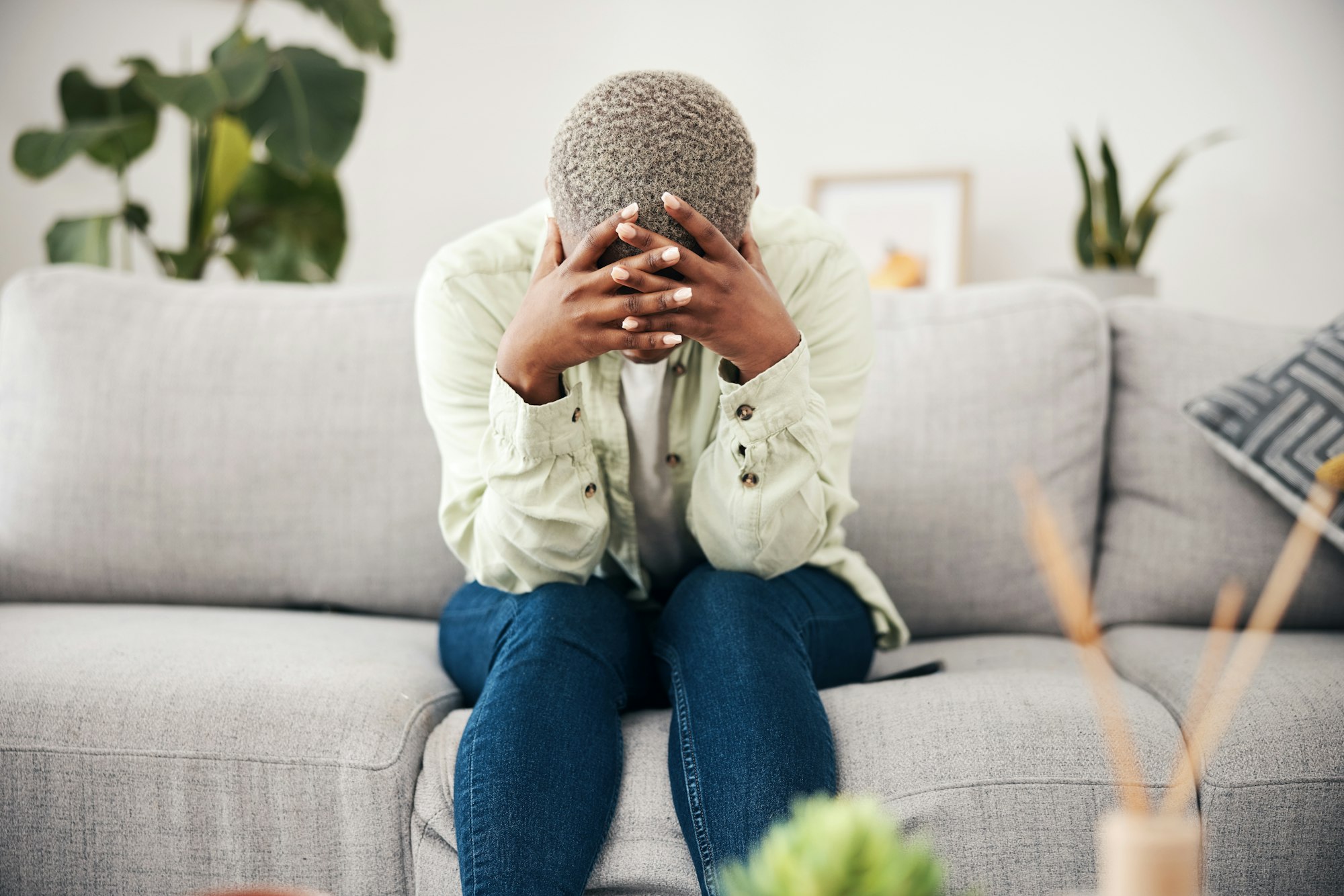 Woman, headache and depression on sofa for mental health, anxiety and stress of bad mistake at home